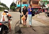 Hỗ trợ hai người nước ngoài cầm bảng xin cứu giúp trên đường phố